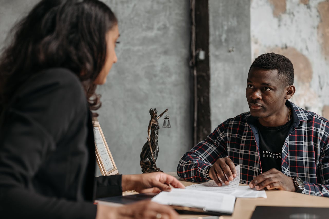 Business meeting between a lawyer and client in a professional office setting.